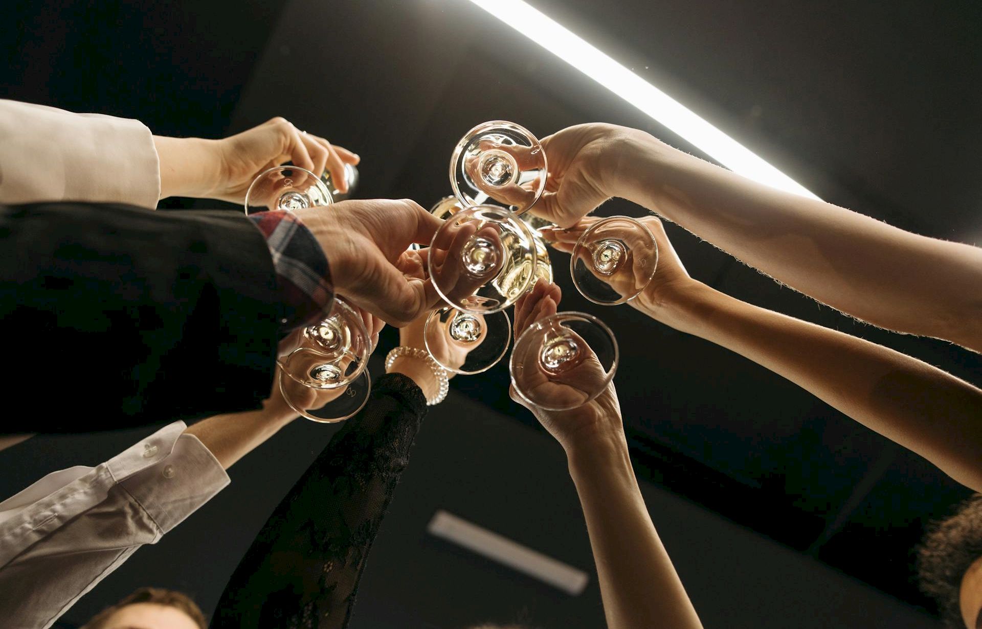 A group of people toasting with glasses in a circle, seen from above, celebrating together. Top it at 140 characters, always ending the sentence.